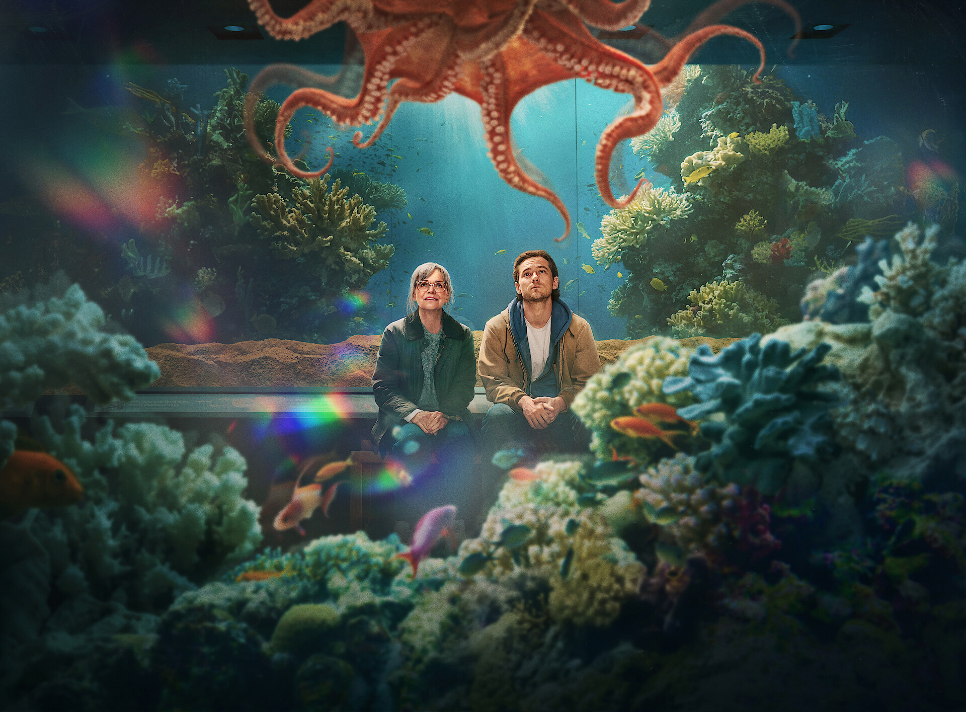 The image shows the protagonists of the film staring at the contents of an aquarium tank.